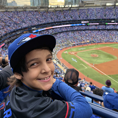 Author Max Arseneau smiling at a baseball game